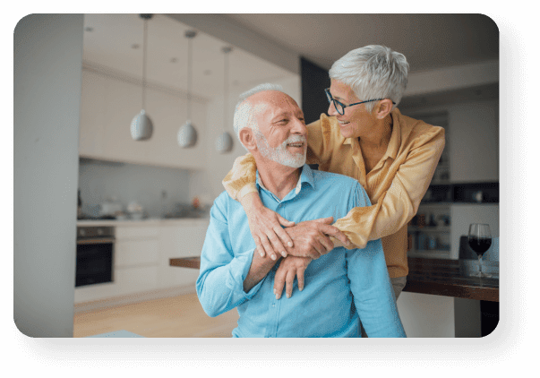 Older Couple Hugging In Kitchen